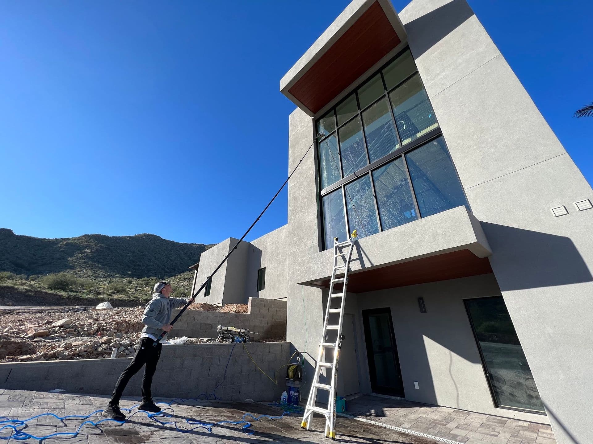 Paradise Washing technician cleaning the windows of a modern Arizona home
